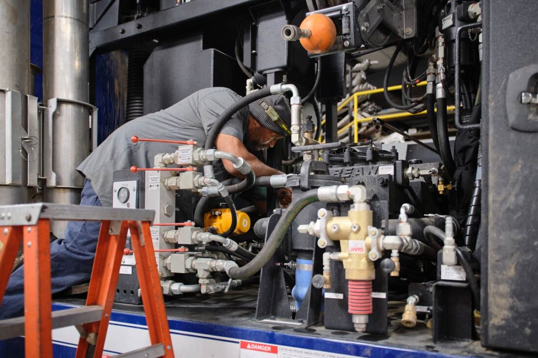 Central Garage at work - Gallery image A mechanic deep in the inner working of one of the city's vactor trucks